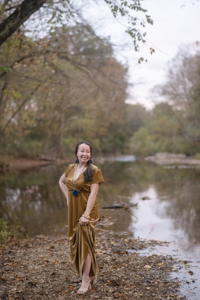 travel blogger and culture blogger, Amy, in front of a creek during a travel adventure