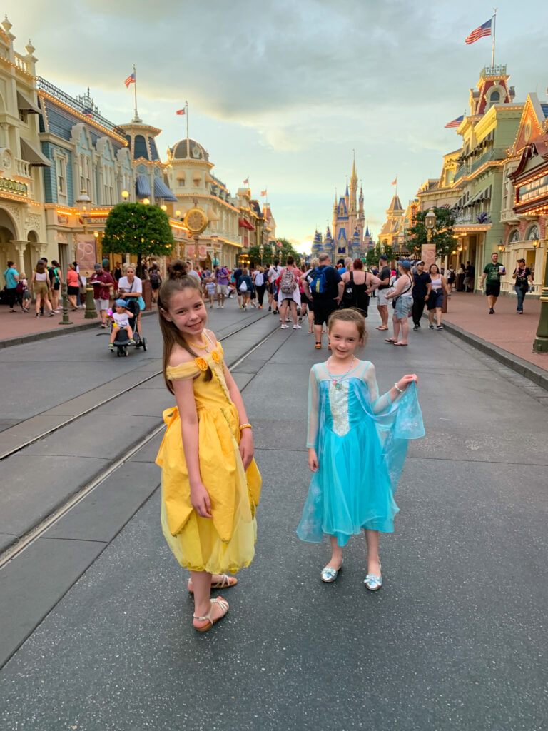 two girls on Main Street in front of the castle for best international travel places with kids