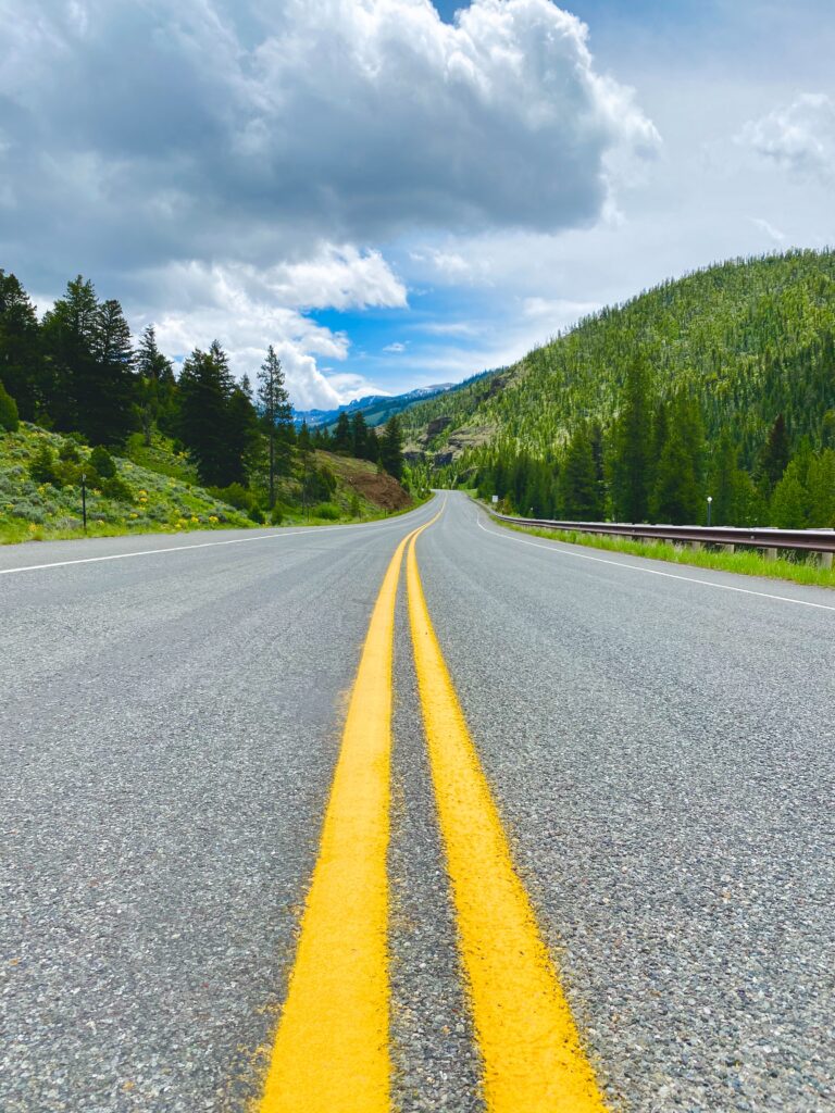 road ahead with hills and trees on post to prepare for a long drive