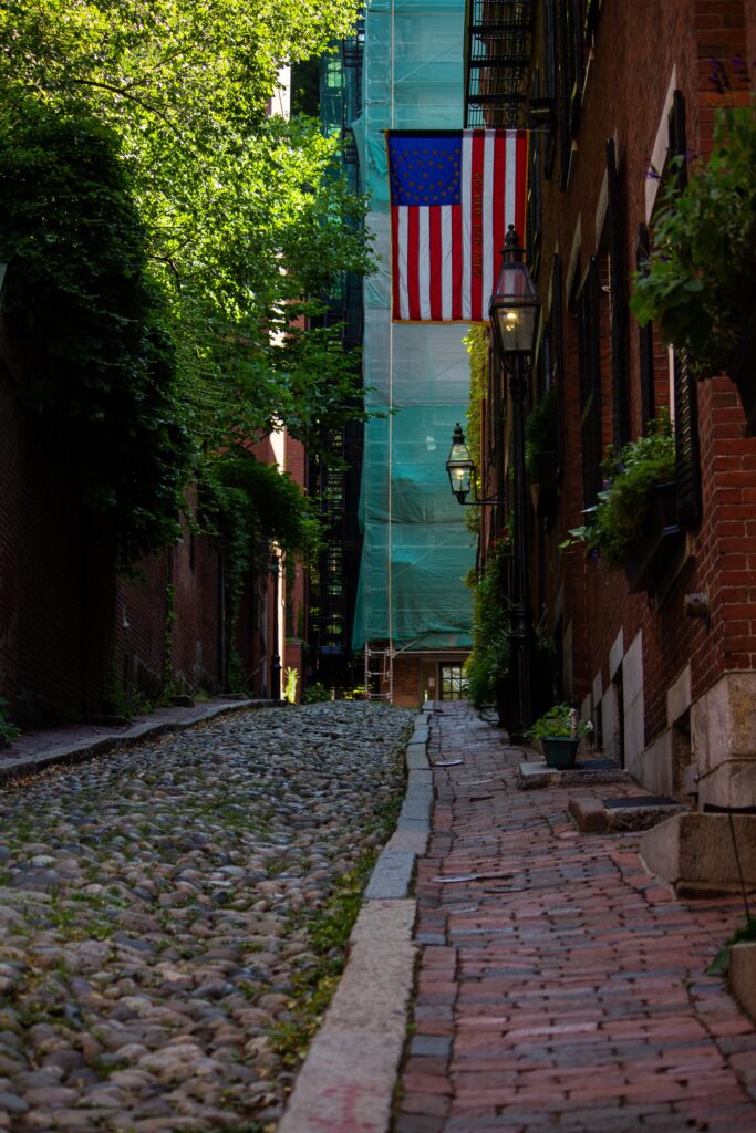 cobblestone street of Boston with flag hanging for top 10 cities to visit