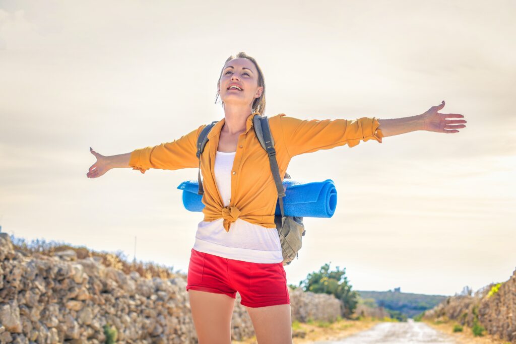 woman stays healthy while traveling with yoga mat on back