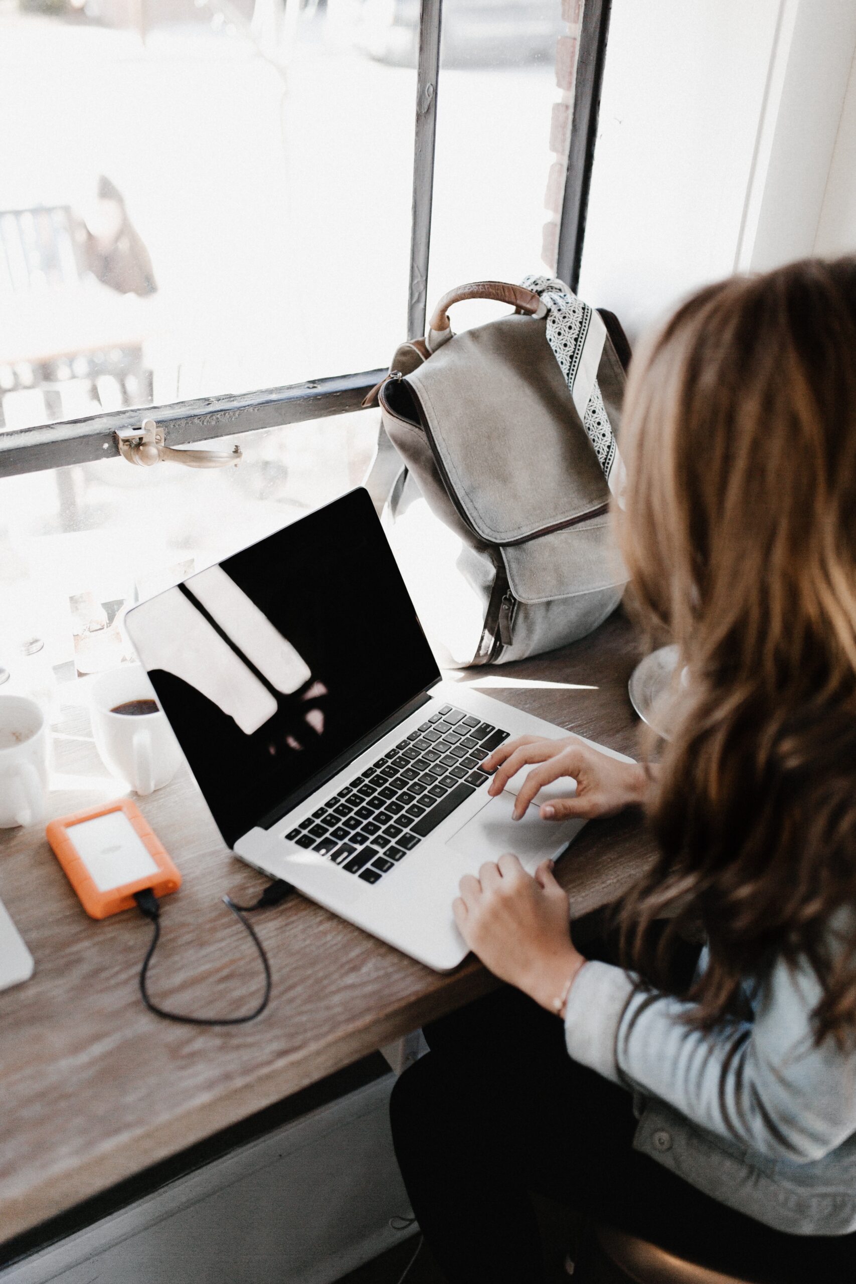 woman studied German at laptop with backpack on desk