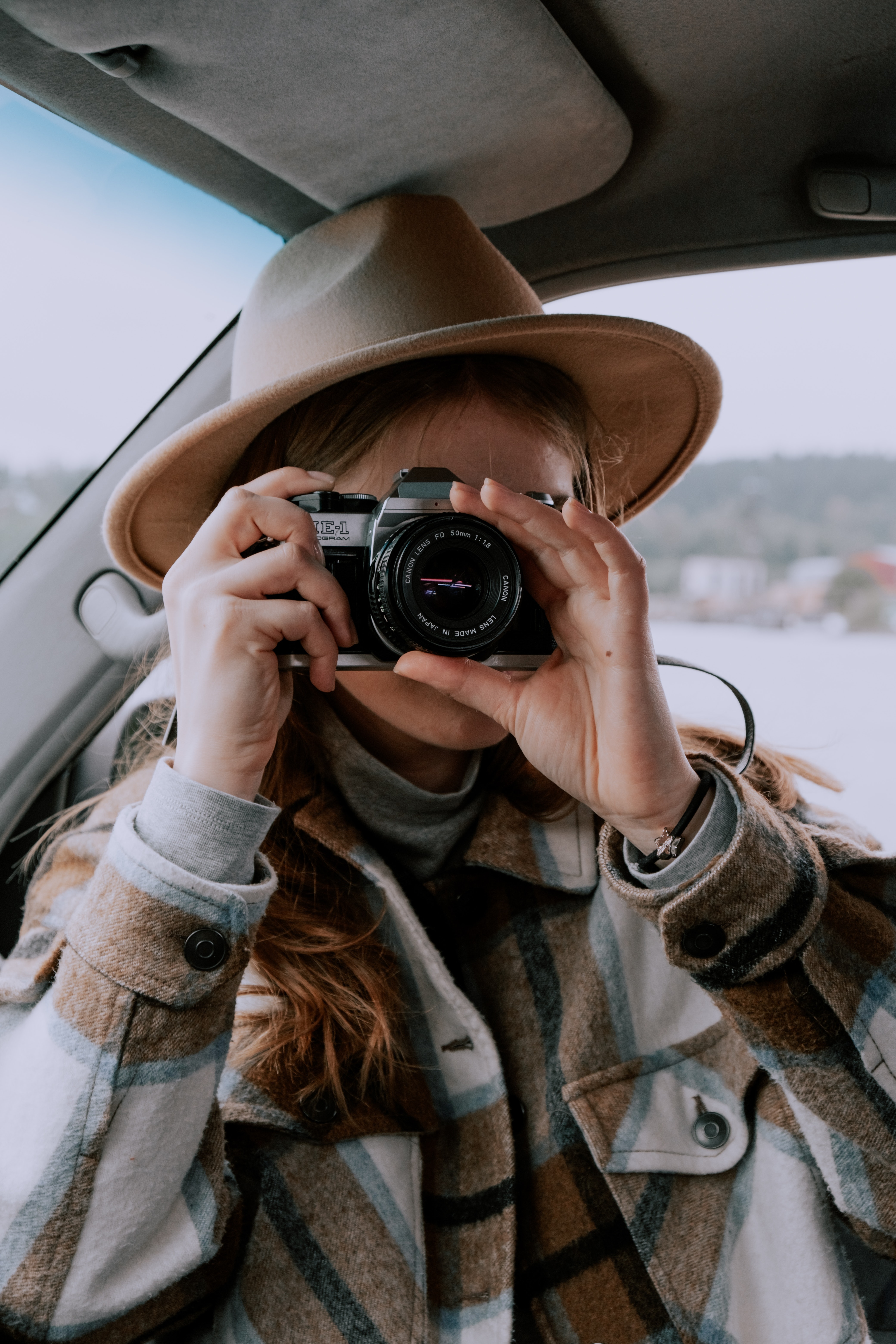 woman holds camera for road tip trips inside a car