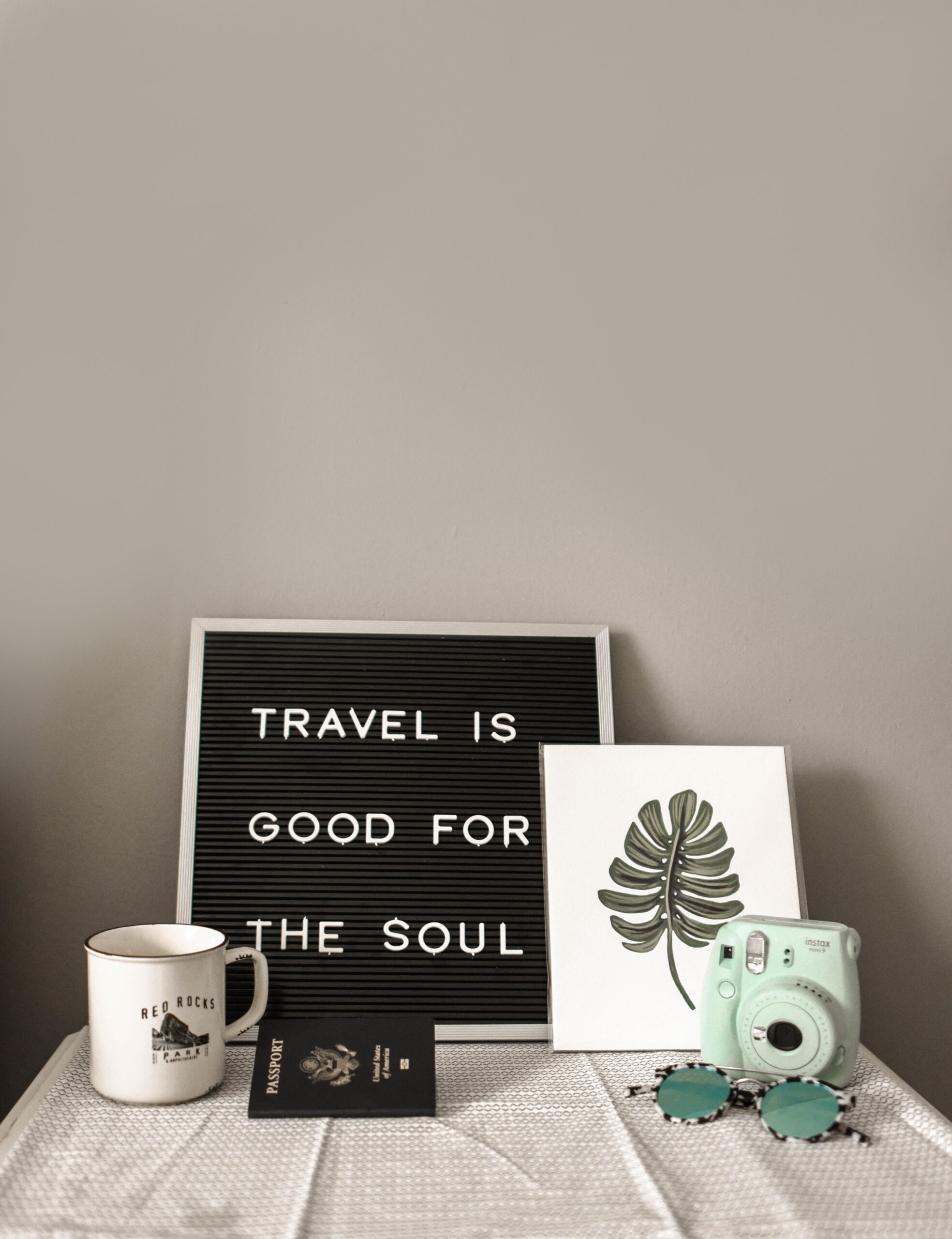 advantages of travel letter board on table with coffee mug, passport, Polaroid camera