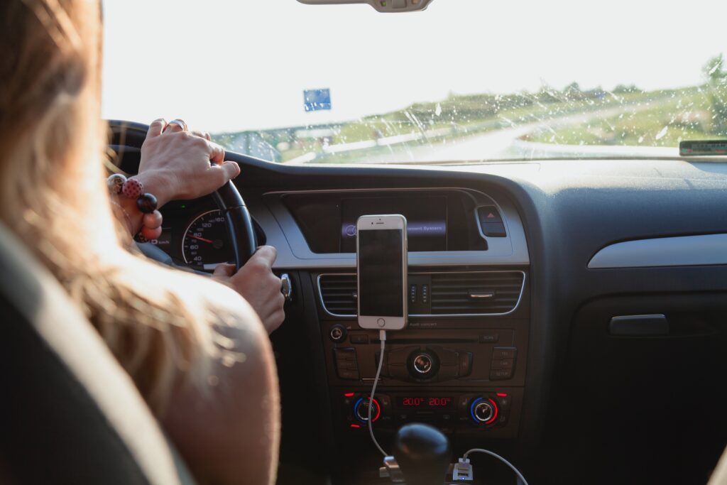 woman behind wheel in dashboard shot on road trip destination image